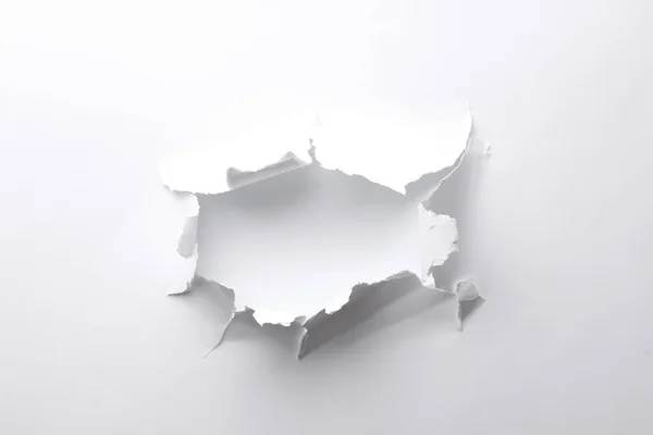 stock image Hole in white paper on light background