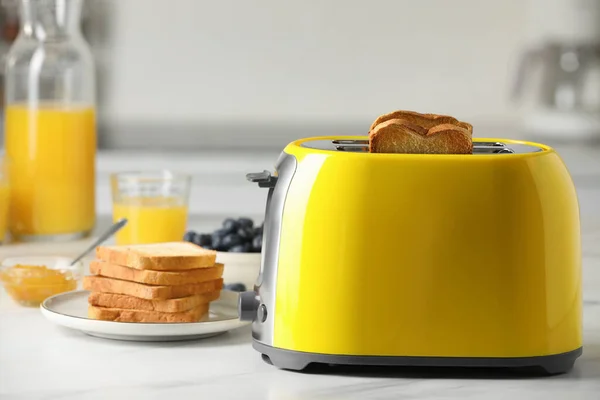 烤面包片 果汁和蓝莓放在白色大理石桌上的黄色烤面包机 — 图库照片