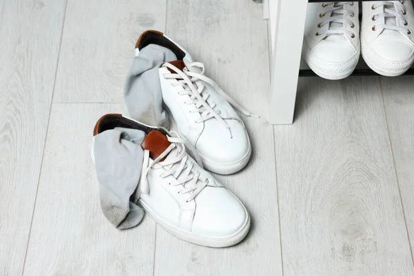 室内白色木制地板上有脏袜子的拖鞋 — 图库照片