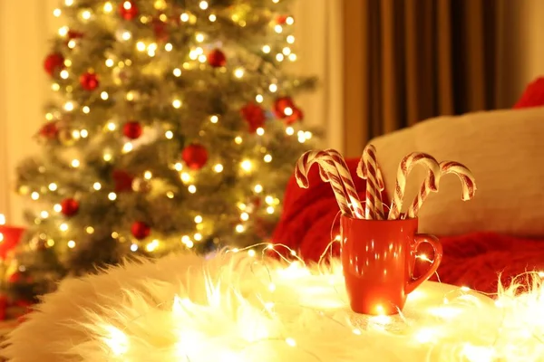 Rote Tasse Mit Zuckerstangen Auf Kunstpelz Weihnachtlich Dekorierten Zimmer Innenarchitektur — Stockfoto
