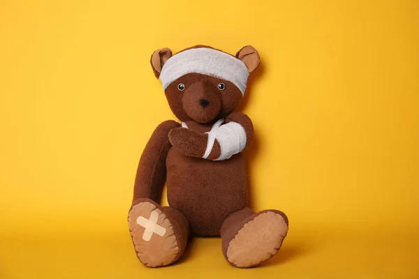 Zabawka Niedźwiedź Bandażami Żółtym Tle — Zdjęcie stockowe