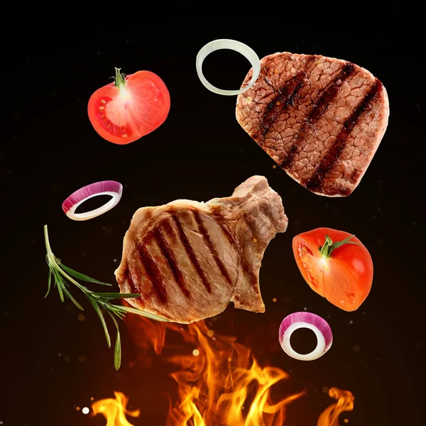 濃い背景の上でおいしい焼き肉 異なる野菜や火の炎 — ストック写真