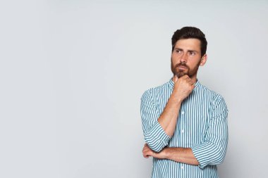 Gri arka planda dalgın sakallı adamın portresi. Metin için boşluk