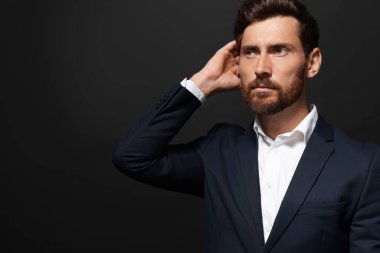 Siyah arka plana bakan yakışıklı sakallı adamın portresi. Metin için boşluk