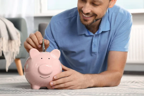 Happy Man Putting Money Piggy Bank Home Closeup — Stock Photo, Image