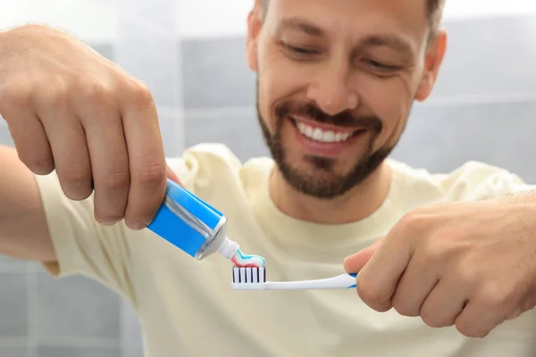 Homem Aplicando Pasta Dentes Escova Banheiro Foco Mãos — Fotografia de Stock