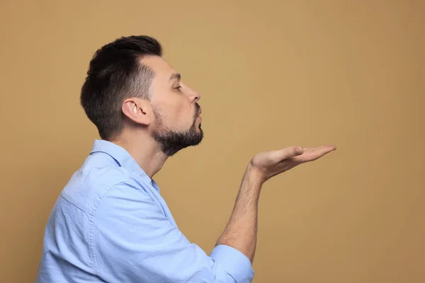 stock image Handsome man blowing kiss on beige background. Space for text