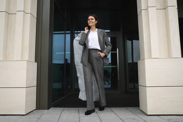 服を屋外でカバーを保持する魅力的な幸せなビジネス女性 ドライクリーニングサービス — ストック写真