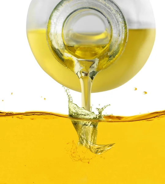 Pouring cooking oil from jug against white background