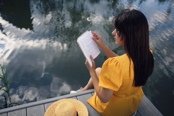 女人在湖边的码头看书 俯瞰上方 — 图库照片