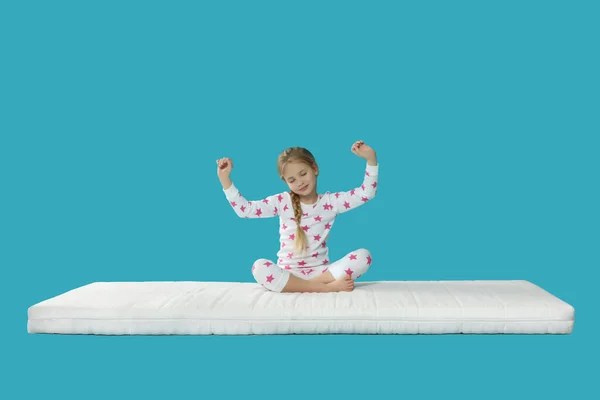 Kleines Mädchen Wacht Auf Matratze Vor Hellblauem Hintergrund Auf — Stockfoto