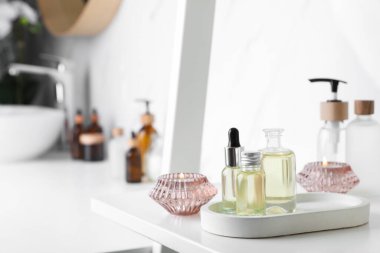 Banyodaki beyaz rafta gerekli yağlar ve mumlar. Metin için boşluk