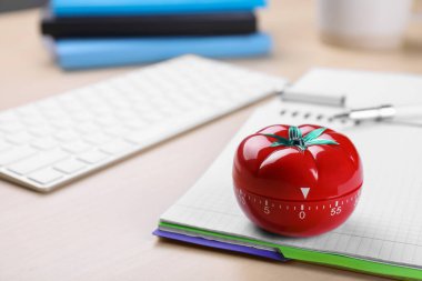 Domates şeklinde mutfak zamanlayıcısı ve ahşap masa üzerinde defter, metin için boşluk