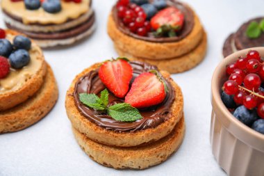 Açık gri masada farklı malzemelerle lezzetli organik ruslar, yakın plan.