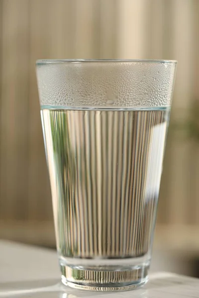 Egy Pohár Tiszta Víz Fehér Asztalon Homályos Háttér Közelkép — Stock Fotó