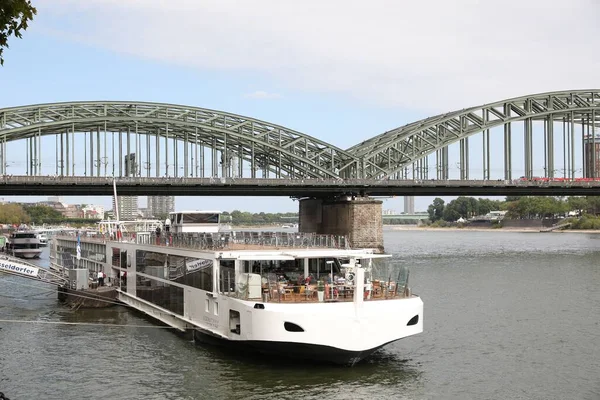 Stock image Cologne, Germany - August 28, 2022: Picturesque view of a modern bridge over river and ferry boat