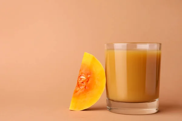 ガラスでおいしいカボチャジュースと薄いオレンジの背景にカボチャをカット テキストのスペース — ストック写真