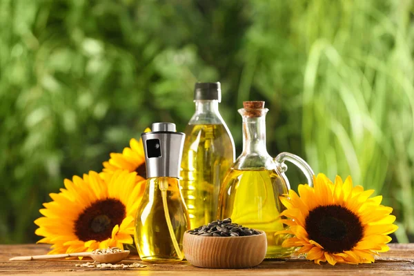 Viele Verschiedene Flaschen Mit Speiseöl Sonnenblumenkernen Und Blumen Auf Holztisch — Stockfoto