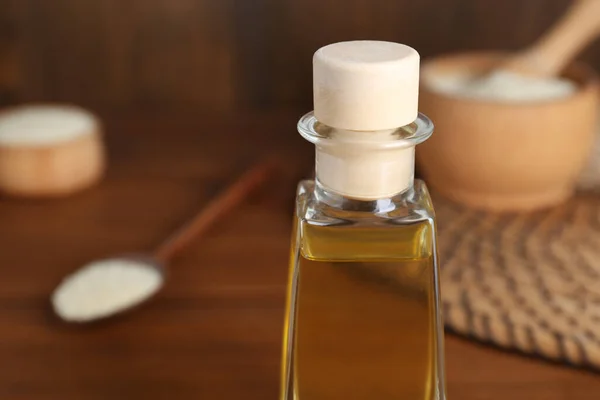 Fresh sesame oil in glass bottle on table, closeup. Space for text