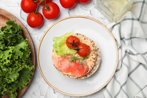 stock image Crunchy buckwheat cakes with salmon, tomatoes and greens on white table, flat lay