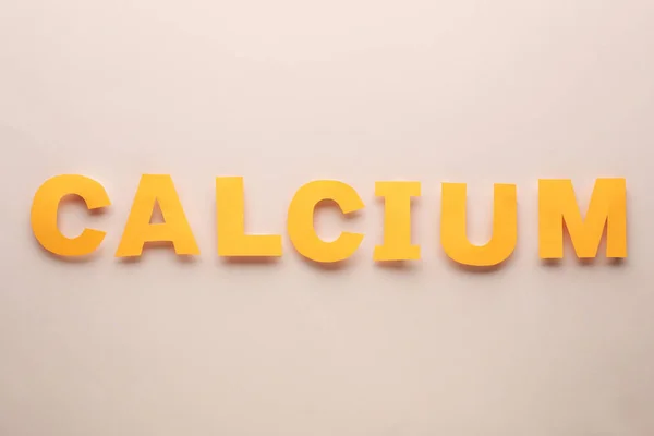 ベージュ地にオレンジの文字で作られたワードカルシウム フラットレイ — ストック写真