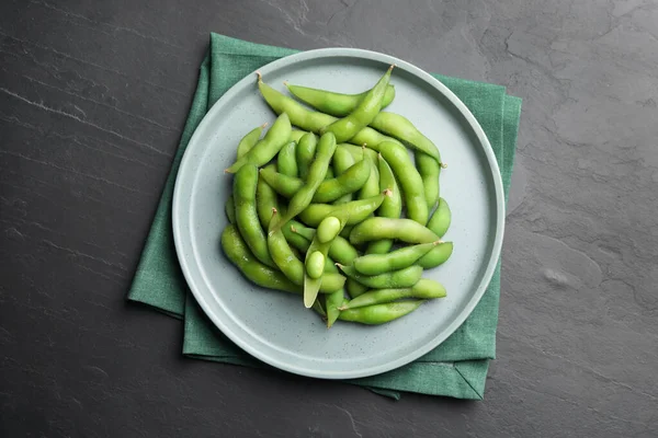 黒いテーブルの上のポッドの緑の枝豆のプレート トップビュー — ストック写真
