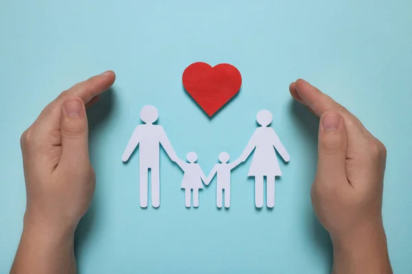 Homem Protegendo Figuras Família Papel Coração Vermelho Fundo Azul Claro — Fotografia de Stock