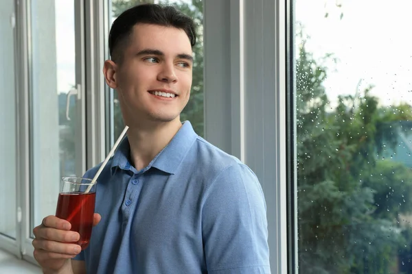 Stilig Ung Man Med Ett Glas Juice Nära Fönstret Hemma — Stockfoto