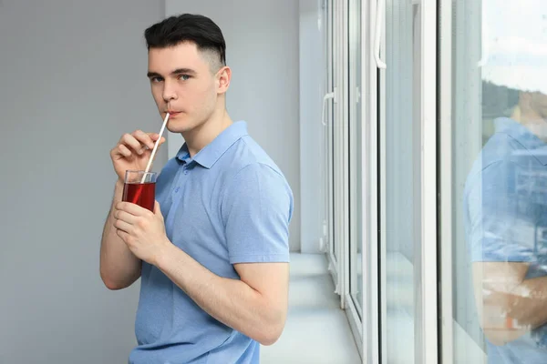 Yakışıklı Genç Adam Evin Penceresinin Yanında Meyve Suyu Içiyor — Stok fotoğraf