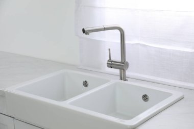Modern lavabo ve musluk mutfağın penceresinin yanında. İç tasarım