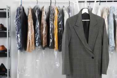 Dark business suit at dry-cleaner's. Space for text clipart