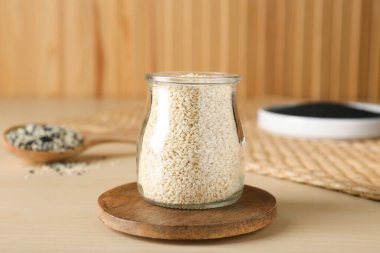 Tahta masada beyaz susam tohumlu cam kavanoz.