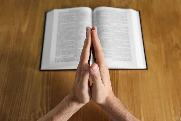 Człowiek Biblią Modlący Się Przy Drewnianym Stole Zbliżenie — Zdjęcie stockowe