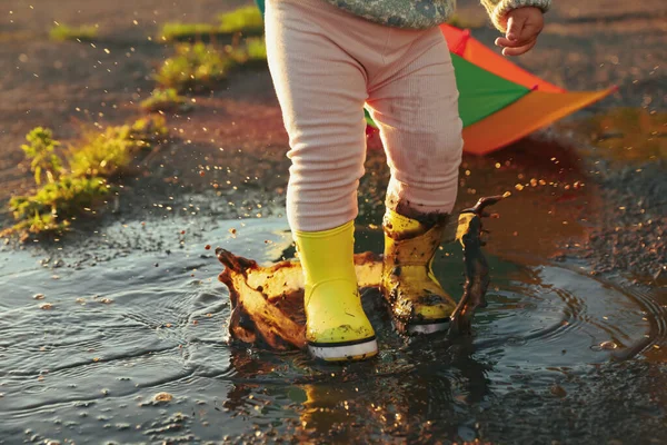 小さな女の子身に着けているゴムブーツで歩くで水たまり屋外 閉鎖とスペースのためのテキスト — ストック写真