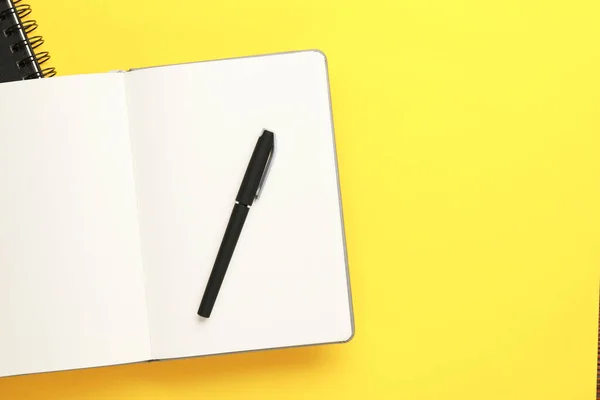黄色の背景 トップビューにノートブックとペン テキスト用のスペース — ストック写真