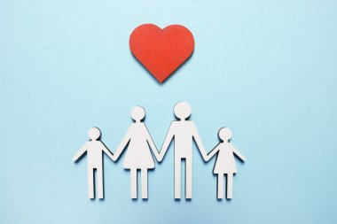 Açık mavi arka planda aile ve kalp figürleri, üst manzara. Sigorta konsepti