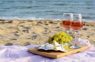 Gül şarabı ve kumlu sahilde atıştırmalık bardaklar. Metin için boşluk