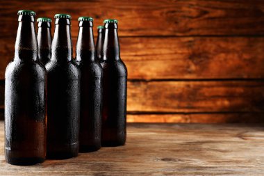 Ahşap masada bir sürü bira şişesi, mesaj için yer.