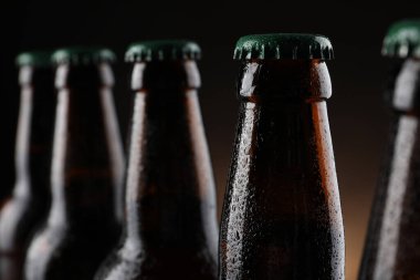 Arka planda bir sürü bira şişesi, yakın plan.