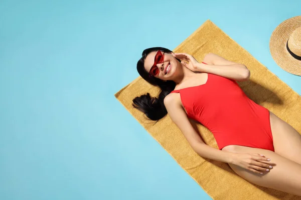 Plaj Havlusunda Açık Mavi Arka Planda Şık Mayo Giymiş Genç — Stok fotoğraf