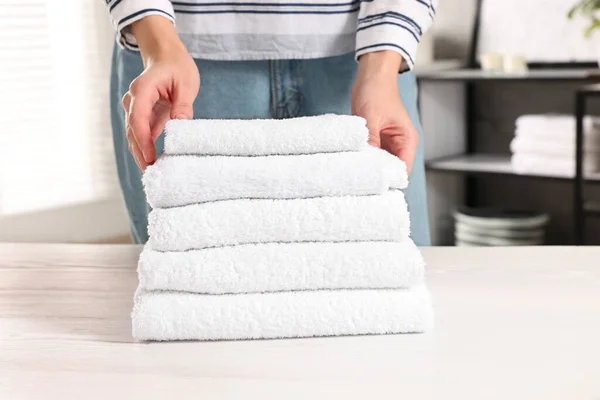 Kobieta Układanie Czyste Ręczniki Białym Stole Pralni Zbliżenie — Zdjęcie stockowe