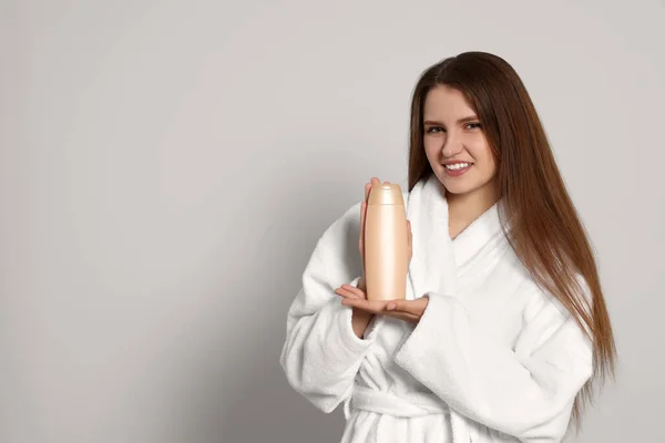 Schöne Junge Frau Bademantel Mit Einer Flasche Shampoo Auf Hellgrauem — Stockfoto
