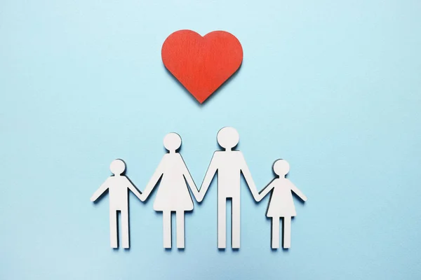 stock image Figures of family and heart on light blue background, top view. Insurance concept