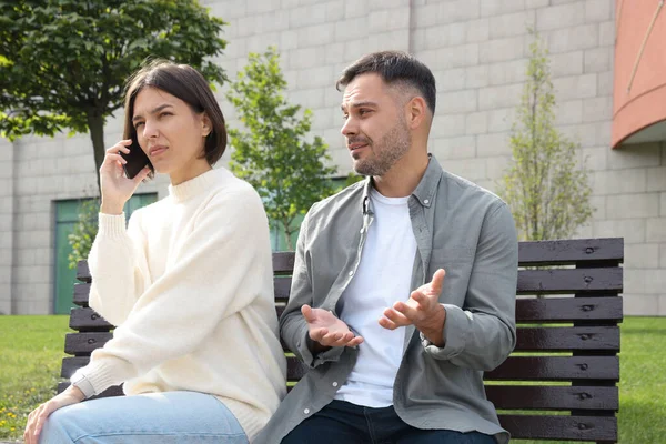 stock image Woman ignoring her boyfriend and talking on phone. Relationship problems