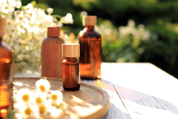 Bottles Essential Oil Flowers White Wooden Table Outdoors Space Text — Zdjęcie stockowe