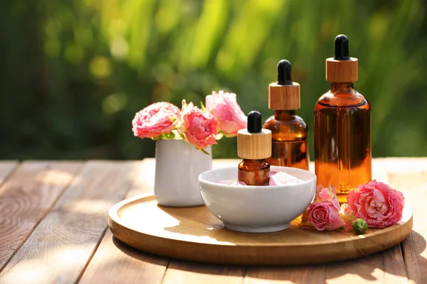 Bottles Rose Essential Oil Flowers Wooden Table Outdoors Space Text — Foto de Stock