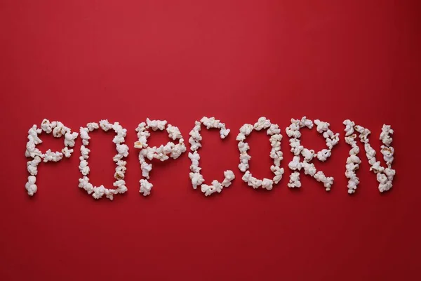 Word Popcorn Gemaakt Van Smakelijke Ingrediënten Rode Achtergrond Plat Lay — Stockfoto