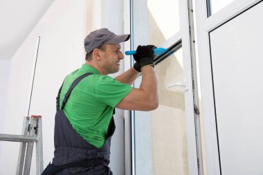 Üniformalı işçiler içeri çift camlı pencere kuruyor