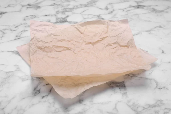 白い大理石のテーブルの上に紙を焼くシート — ストック写真