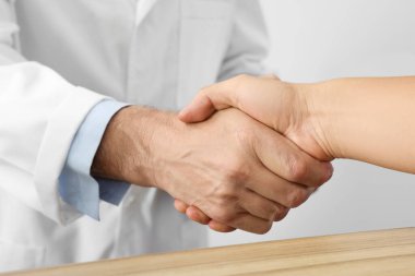 Hastanedeki hastayla el sıkışan doktor, yakın plan.